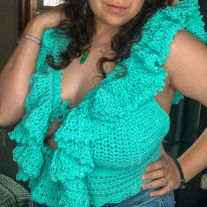 A woman with curly brown hair models the Juniper Top in teal, tilted towards the left of the camera. 