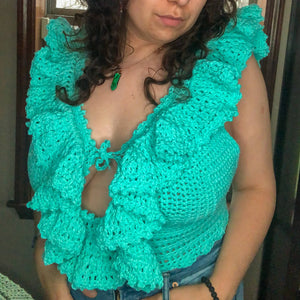 A woman with brown curly hair models the Juniper Top in teal. 