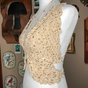 An extra small butterfly top is on a mannequin and tilted halfway between a full profile and facing the camera to show off the shaping of the top. In the background are multiple wall decorations including a mushroom mirror and porcelain birds. 